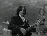 a man is playing a guitar in a black and white photo