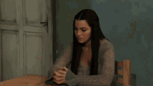 two women sit at a table in a living room