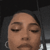 a close up of a woman 's face with a nose ring and earrings