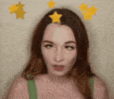 a woman wearing a green tank top with three yellow stars on her head