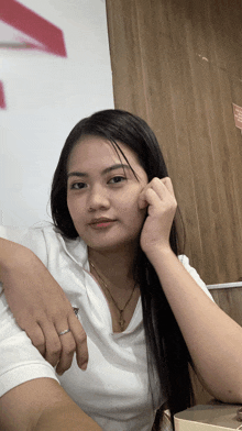 a woman wearing a white shirt and a gold necklace