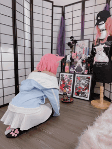 a woman with pink hair is kneeling down in front of a shelf with a wanted poster