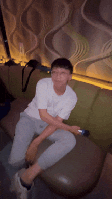 a man is sitting on a couch holding a microphone