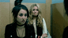 a woman with a choker on her neck is standing next to another woman