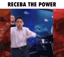a boy is dancing in front of a fish tank with the words receba the power above him .