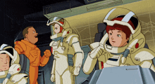 a group of astronauts are standing in a room and one of them is wearing a helmet that says ' x '