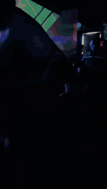 a man without a shirt is dancing in a dark room with other people