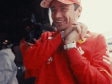 a man wearing a red sweater with the word ferrari on it