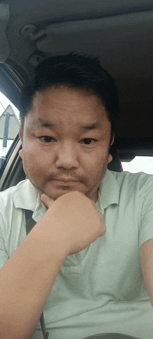 a man with a beard is sitting in the driver 's seat of a car