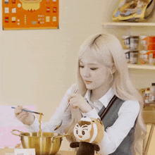a woman eating noodles with chopsticks next to a stuffed animal that says monkey on it