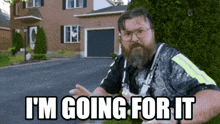 a man with a beard says i 'm going for it in front of a house