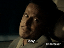 a man in a suit is sitting in a car with the words baby written below him