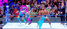 a group of wrestlers are standing in a wrestling ring with a referee .