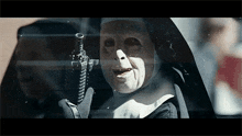 a nun is holding a gun in a car window