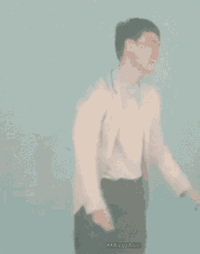a man in a white jacket and black pants is standing in front of a blue wall with the word mavwave on the bottom right