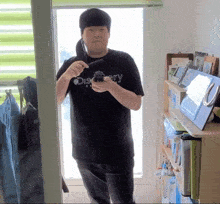 a man wearing a black shirt that says discovery is holding a camera