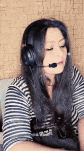 a woman wearing headphones and a microphone with a striped shirt