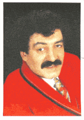 a man with curly hair and a mustache is wearing a red jacket and tie