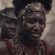 a close up of a woman wearing a headband with coins and beads on it