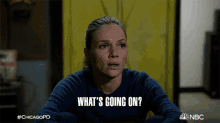 a woman in a blue sweater is asking what 's going on