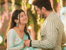 a man and a woman are looking at each other and the woman is smiling .