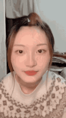 a close up of a woman 's face with a bun in her hair