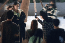a man taking a picture of a girl with a phone