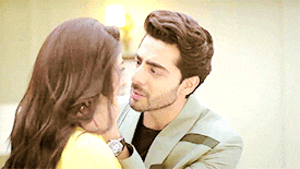 a man in a suit is kissing a woman on the forehead .