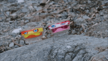 a plastic container with a face on it is sitting on a rock