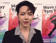 a man stands in front of a poster that says move 9 pm