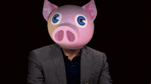 a man in a suit with a pink pig mask on his head