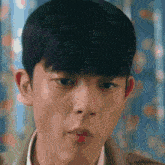 a close up of a young man 's face with a fringe