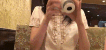 a woman is taking a picture of herself with a camera in a restaurant .