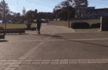 a person riding a skateboard down a sidewalk in front of a building that says ucsd