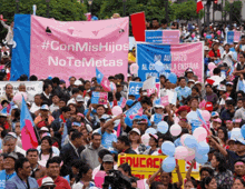 a crowd of people holding balloons and a sign that says #conmishijos no temetas