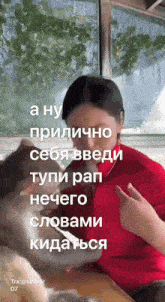 a woman in a red shirt is sitting next to a dog with a caption in russian