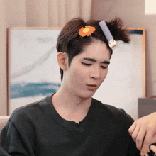 a man with a flower in his hair and a hair curler on his head