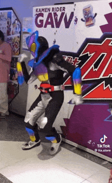 a person in a kamen rider costume is dancing in front of a sign that says kamen rider gavv