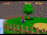 a video game character is standing next to a tree and a wooden fence .