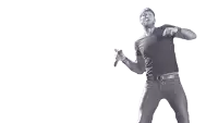 a man in a black shirt and jeans is standing in front of a white background .