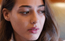 a close up of a woman 's face with a slight smile on her face