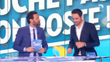two men are standing in front of a screen that says touche pas mon poste