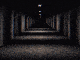 a dark hallway with a light at the end of it