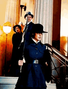 a woman holding a sword in front of a man and a woman