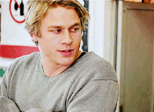 a man wearing a grey sweater is looking at something