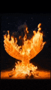 a large fire is coming out of a pile of wood