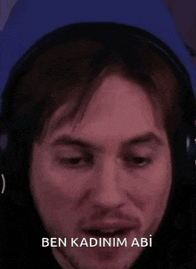 a man wearing headphones is making a funny face with the words ben kadinim abi above him