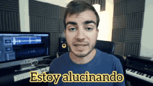 a man in a blue shirt is standing in front of a computer and says estoy alucinando