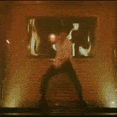 a man in a white shirt and black pants is dancing on a stage .