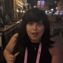 a woman wearing a black top and a pink lanyard with the word shagarita on it